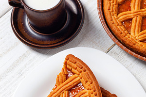 Delicious breakfast with jam tart, milk and cereals on white wooden table, a Food & Drink Photo by Antonio Gravante Market