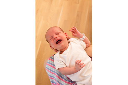 Mom holds her screaming baby in her, a Health & Medical Photo by oksix