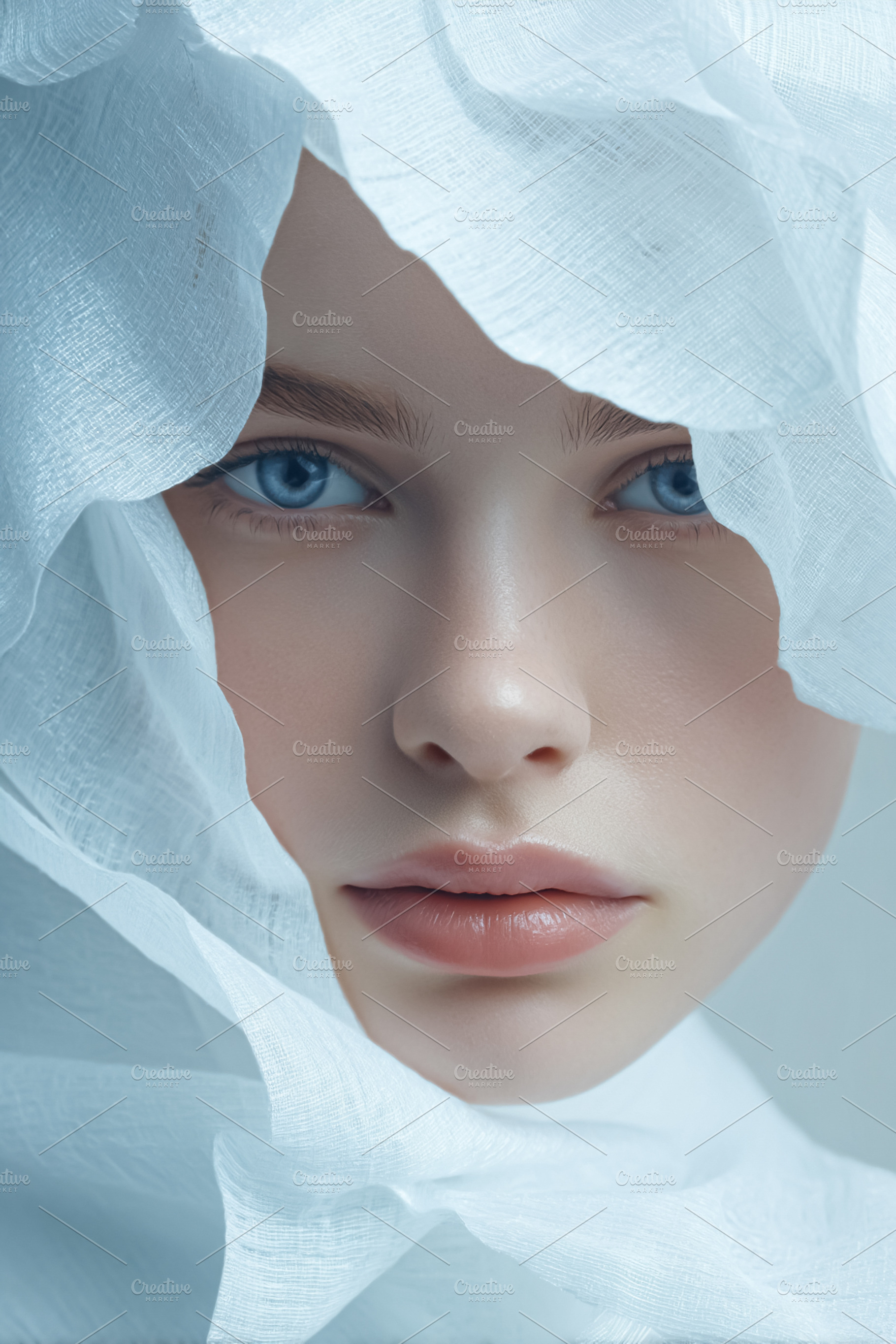 Woman's clear blue eyes emerging from soft white fabric represen, a Photo by Studio ANNA