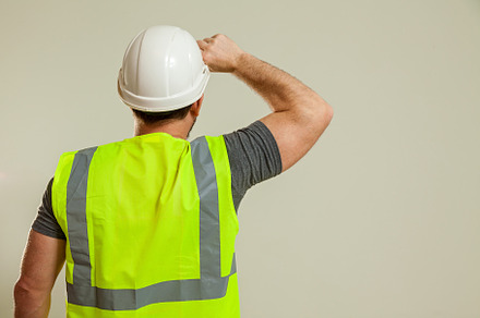 worker in a vest and white helmet, a Person Photo by Photostock