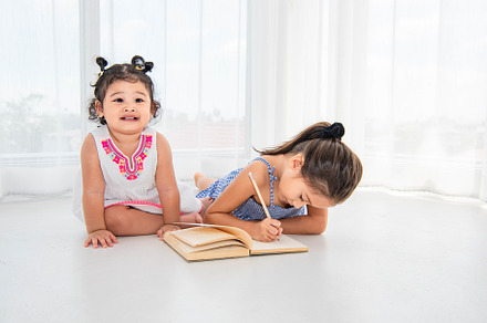 Happy two sister drawing in sketch book together at home or nurs, a Person Photo by Ministocker