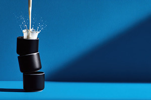 Milk in black cups on blue, a Photo by Beautiful things