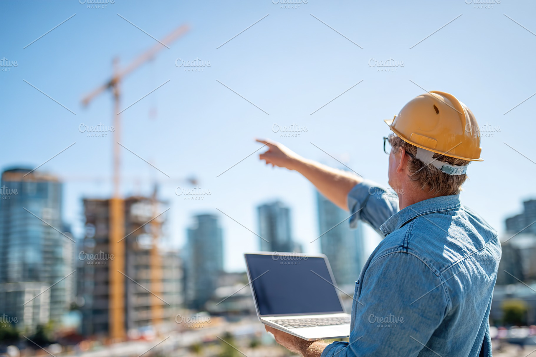 Young male architect directs construction work while demonstrating design ideas, an Industrial Photo by AlyaAnd