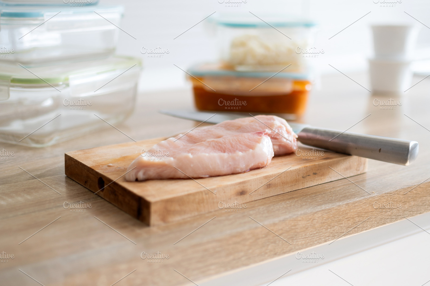 Raw chicken breast fillet on wooden cutting board with glass meal prep containe, a Food & Drink Photo by etorres69