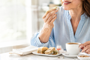 Woman enjoying Turkish sweets with c, a Photo by Dvoevnore photos