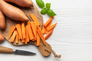 Sweet potato fries preparing on wooden cutting board, a Food & Drink Photo by Olena Rudo