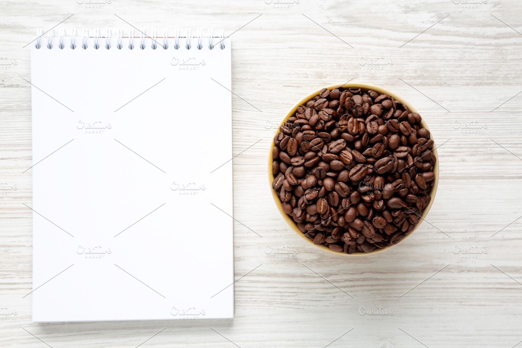 Organic Roasted Coffee Beans in a Bowl, Blank Notepad, top view., a Food & Drink Photo by LiudmylaChuhunova