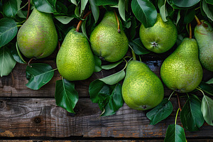 Green pears with leafs on wooden table, a Food & Drink Photo by AlyaAnd