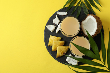 Pina colada cocktails and ingredients on yellow background, a Food & Drink Photo by AtlasStudio PRO