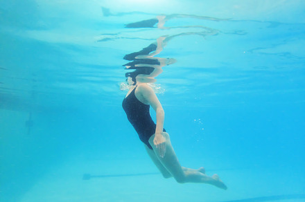 Swimming, fitness and sports with a woman floating in a pool for cardio or endurance exercise. Water, swimwear and health with a female swimmer during an aqua workout or competitive watersports game, a Photo by Peopleimages.com