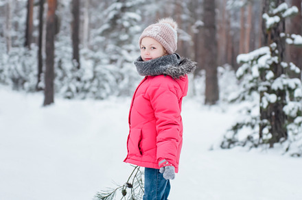 Little girl in a bright jacket plays in the winter forest, a Person Photo by Olena Rudo