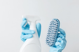 Woman in rubber gloves holding cleaning spray and brush, ready for household cl, a Photo by matucha