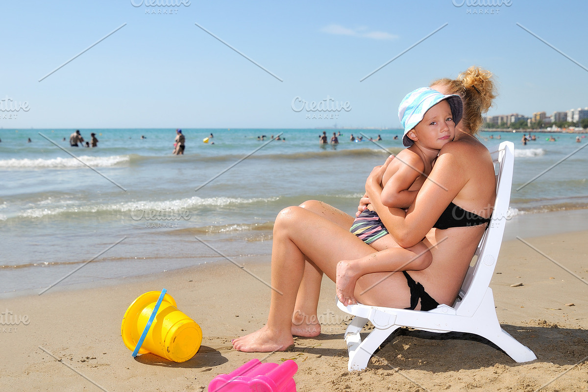 Mother hugging her son on the beach shore, a Person Photo by Davizro's Market (Photo 1 of 2)