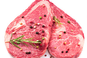 Two fresh ribeye steaks with peppercorn and rosemary isolated on, a Food & Drink Photo by Volff