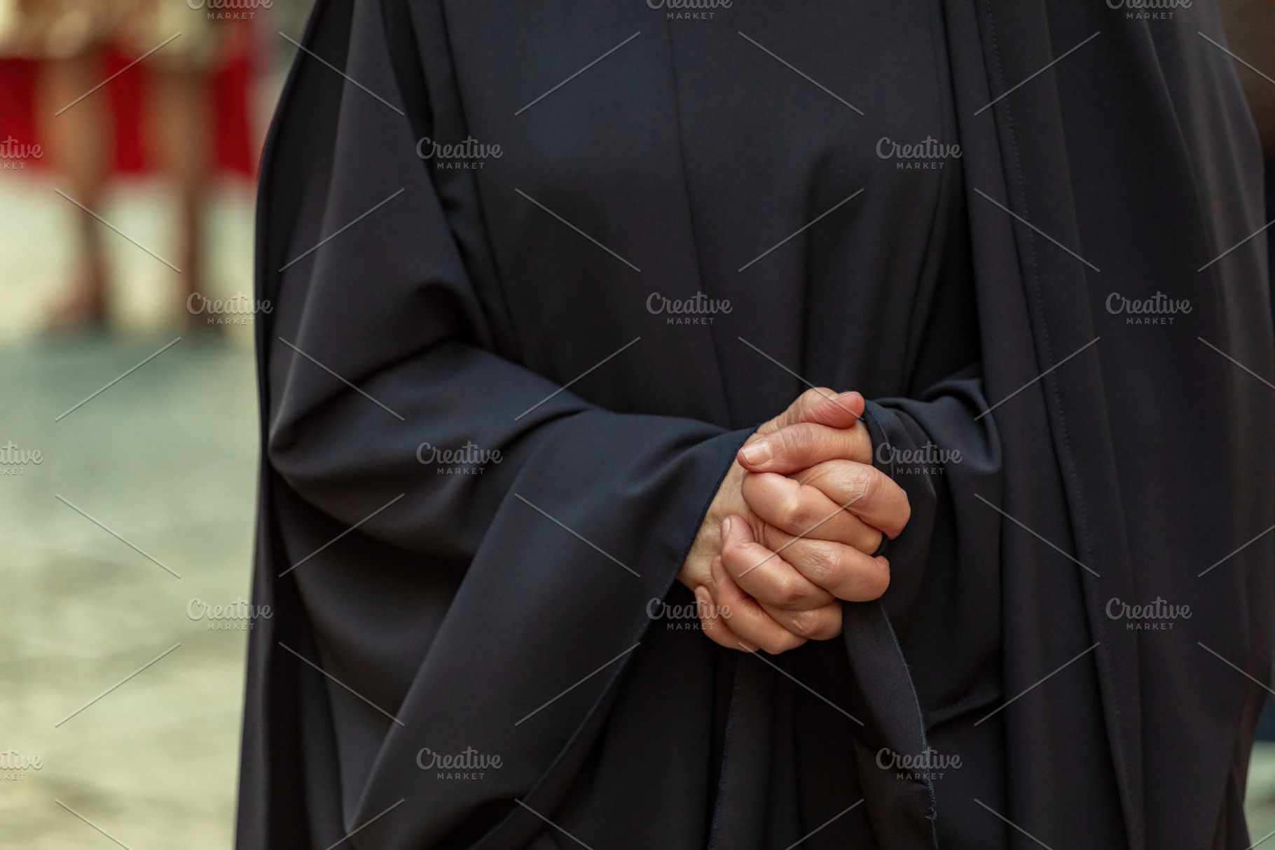 Close-up of a woman clasping her hands in prayer, wearing a black cassock durin, a Holiday Photo by Antonio Gravante Market