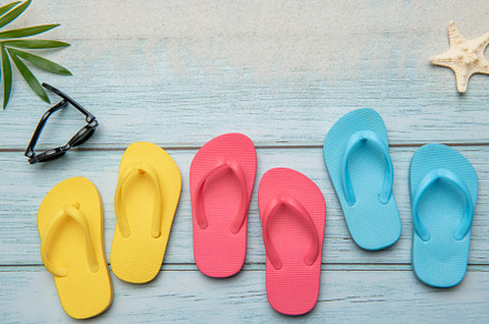 Colorful flip flops and sunglasses resting on beach boardwalk, e
