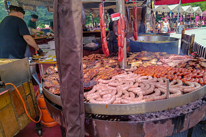 Street grill with sausages at outdoor food market, a Food & Drink Photo by DanFLCreativo