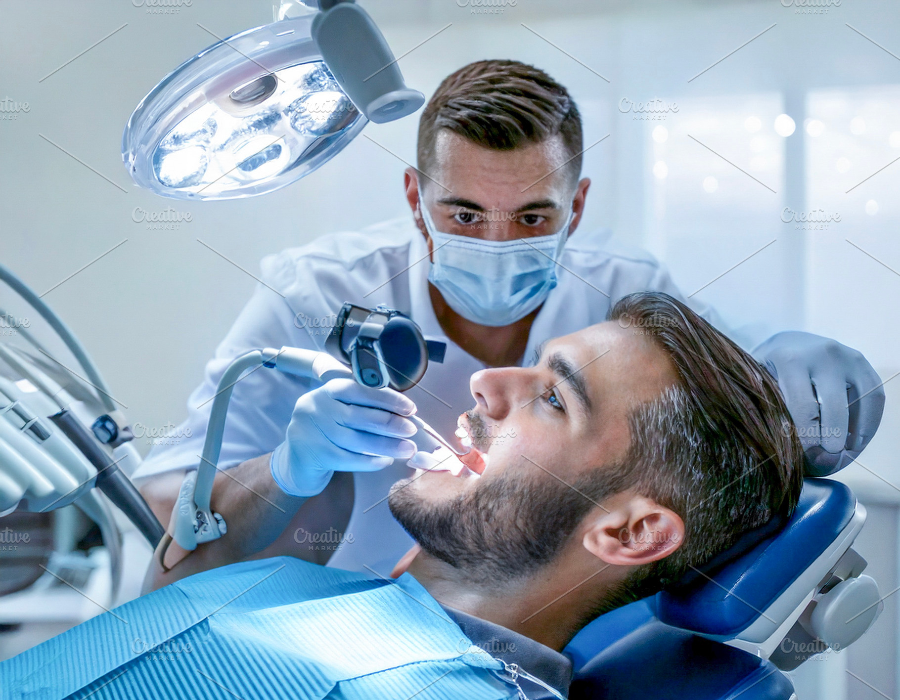 Male dentist performing treatment on patient, a Health & Medical Photo by DanFLCreativo