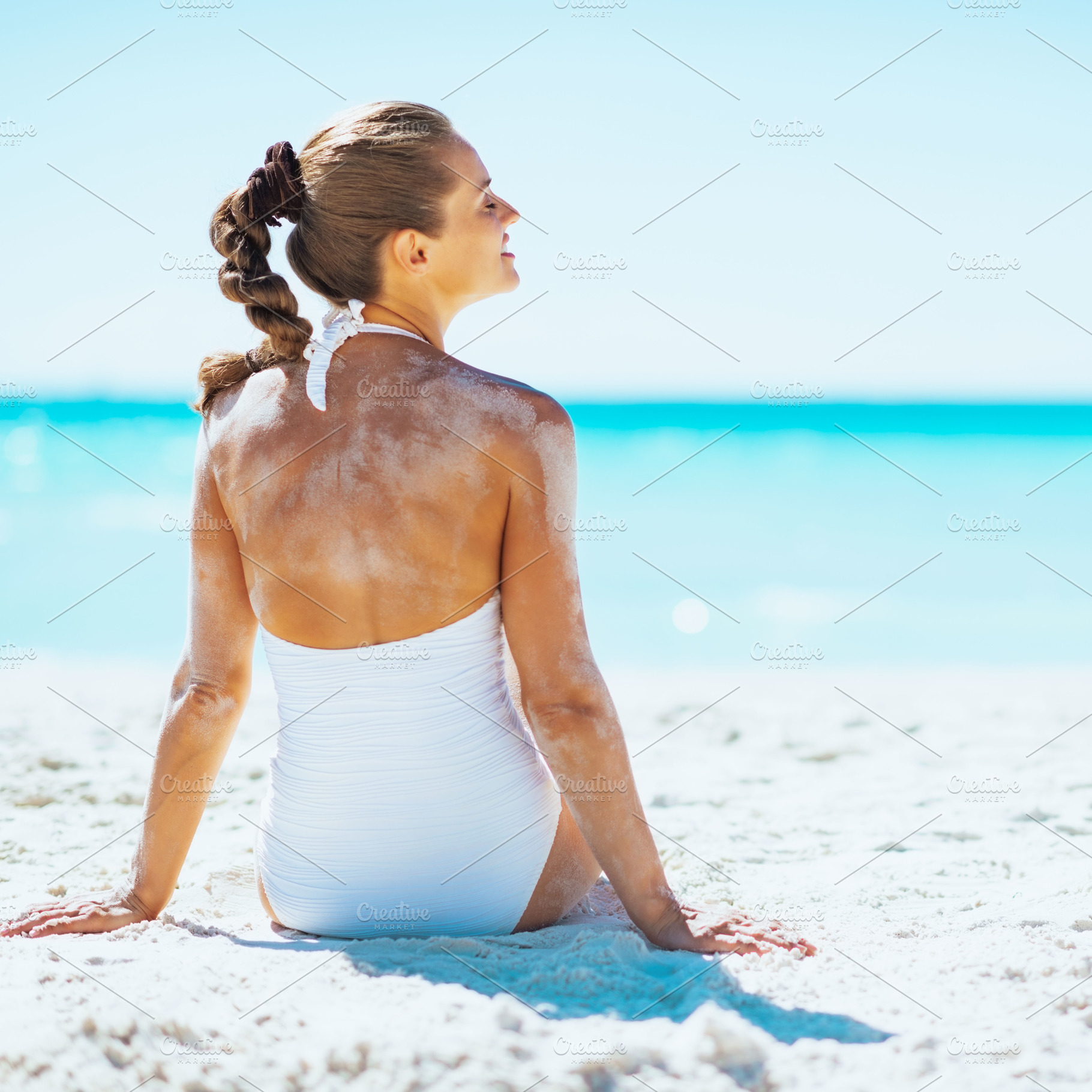 Young woman sitting on beach. rear view, a Person Photo by Alliance Images