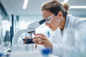 Scientist working with a microscope in laboratory, a Health & Medical Photo by AlyaAnd
