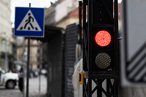Urban scene with pedestrian crossing and traffic light during overcast weather, a Photo by AS photostudio