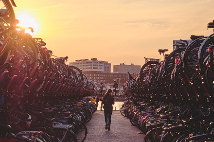 Woman in bicycle parking at sunset