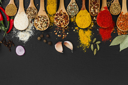 Various spices in wooden spoons containing spoon, spices, and black, a Food & Drink Photo by Nataliia Pyzhova