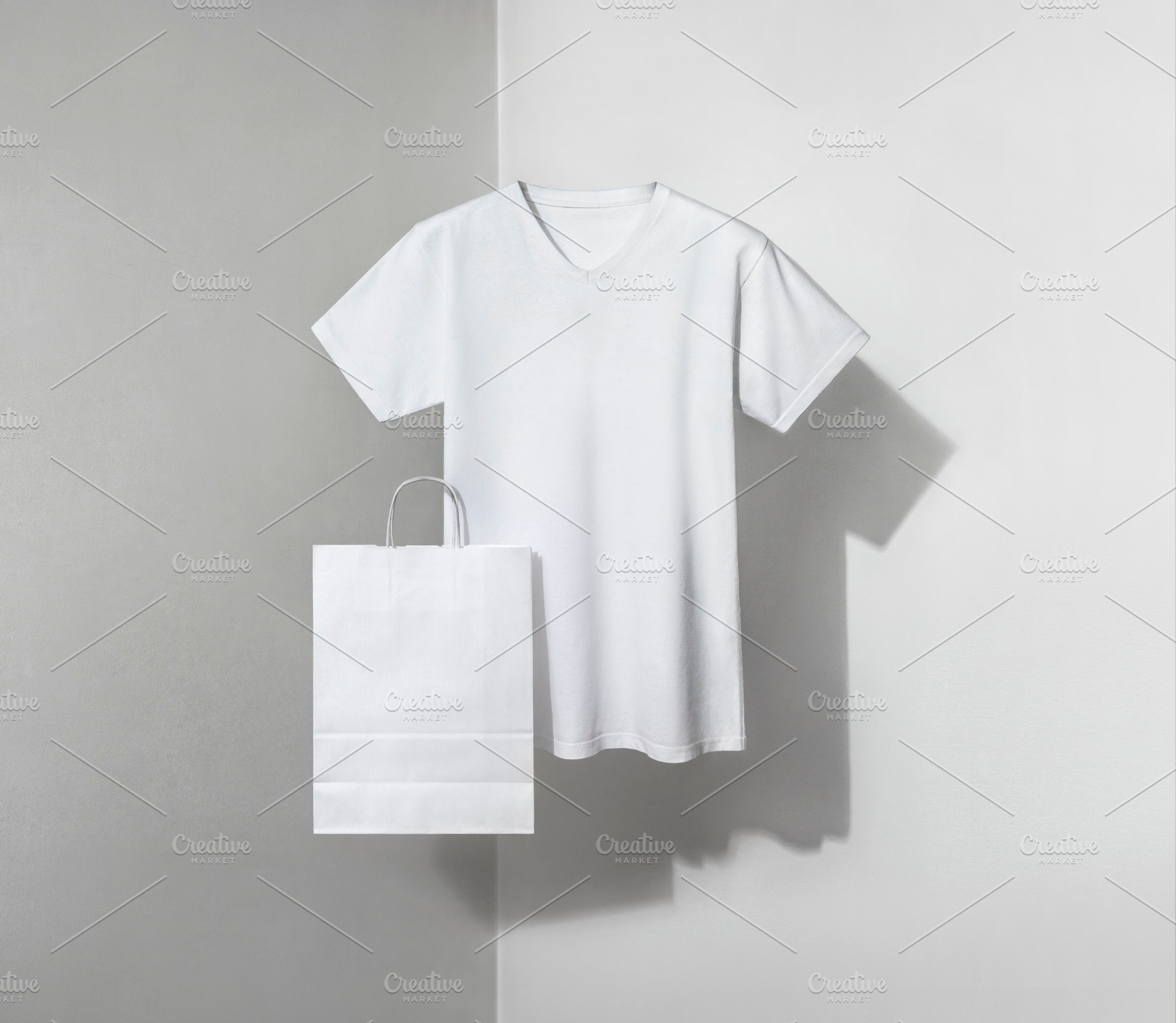 white v-neck t-shirt and paper bag, a Photo by UN-BRANDED