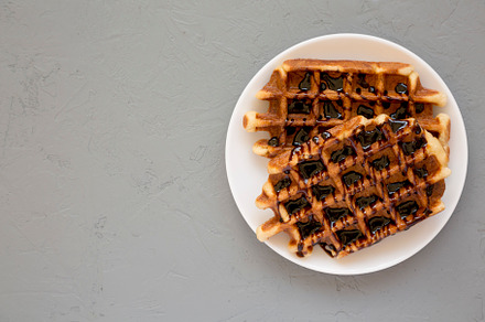 Yummy Homemade Belgian Sugar Waffles on a white plate on a gray, a Food & Drink Photo by LiudmylaChuhunova