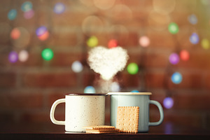two hot cups of coffee with heart shape steam