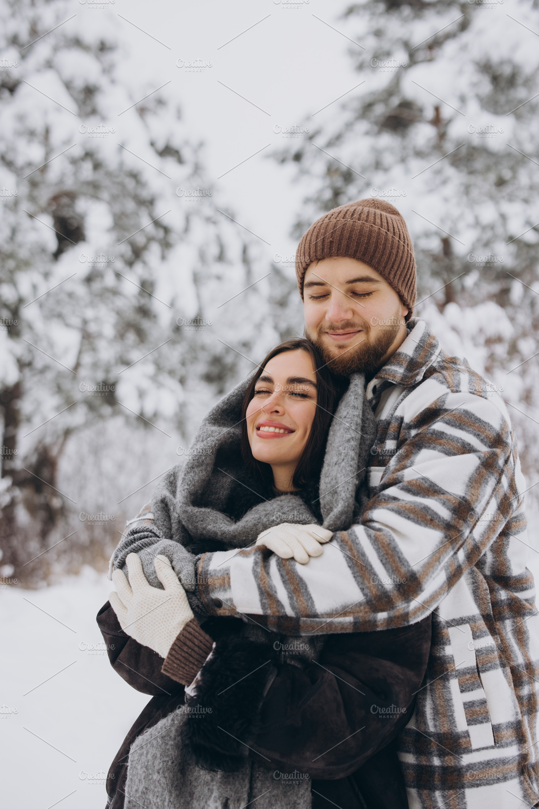 A young happy and loving couple is having fun in a snowy forest, a Person Photo by Cherkas Photography