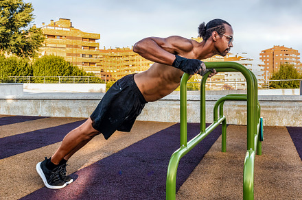 Man doing incline push-ups outdoors, a Sports & Recreation Photo by Perpis