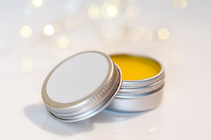 Lip balm in metal jar over lights