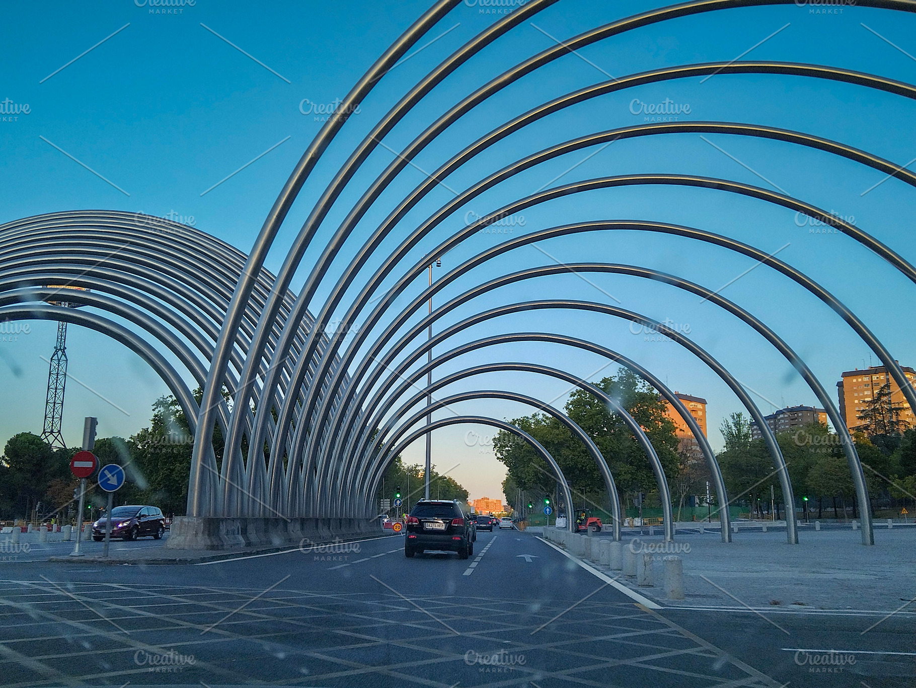 Metal arch tunnel on urban road, a Transportation Photo by DanFLCreativo
