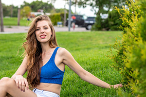 beautiful young woman seated on grass, AI generated, a Photo by WorldOfPhotos