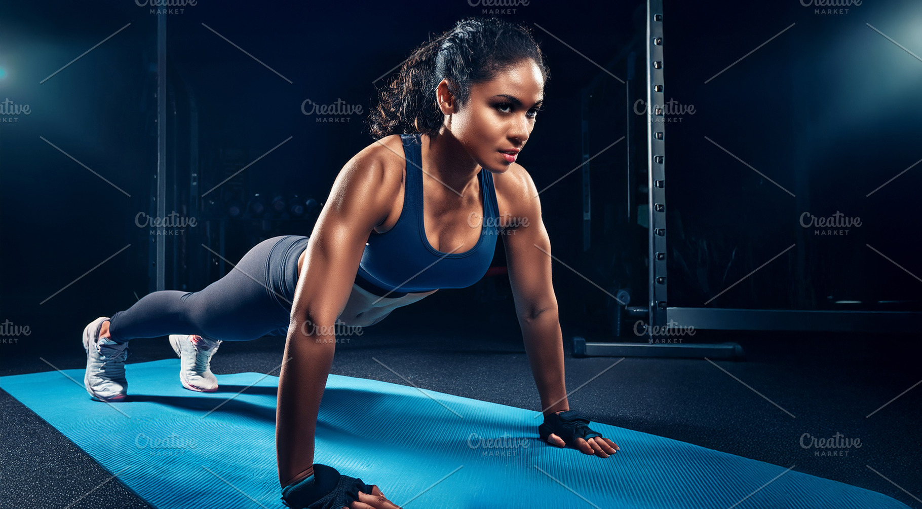 Young black woman doing push-ups on a mat in gym, a Sports & Recreation Photo by Davizro's Market