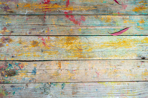 Rustic wooden surface with colorful paint splashes and marks, an Architecture Photo by GoodGoods