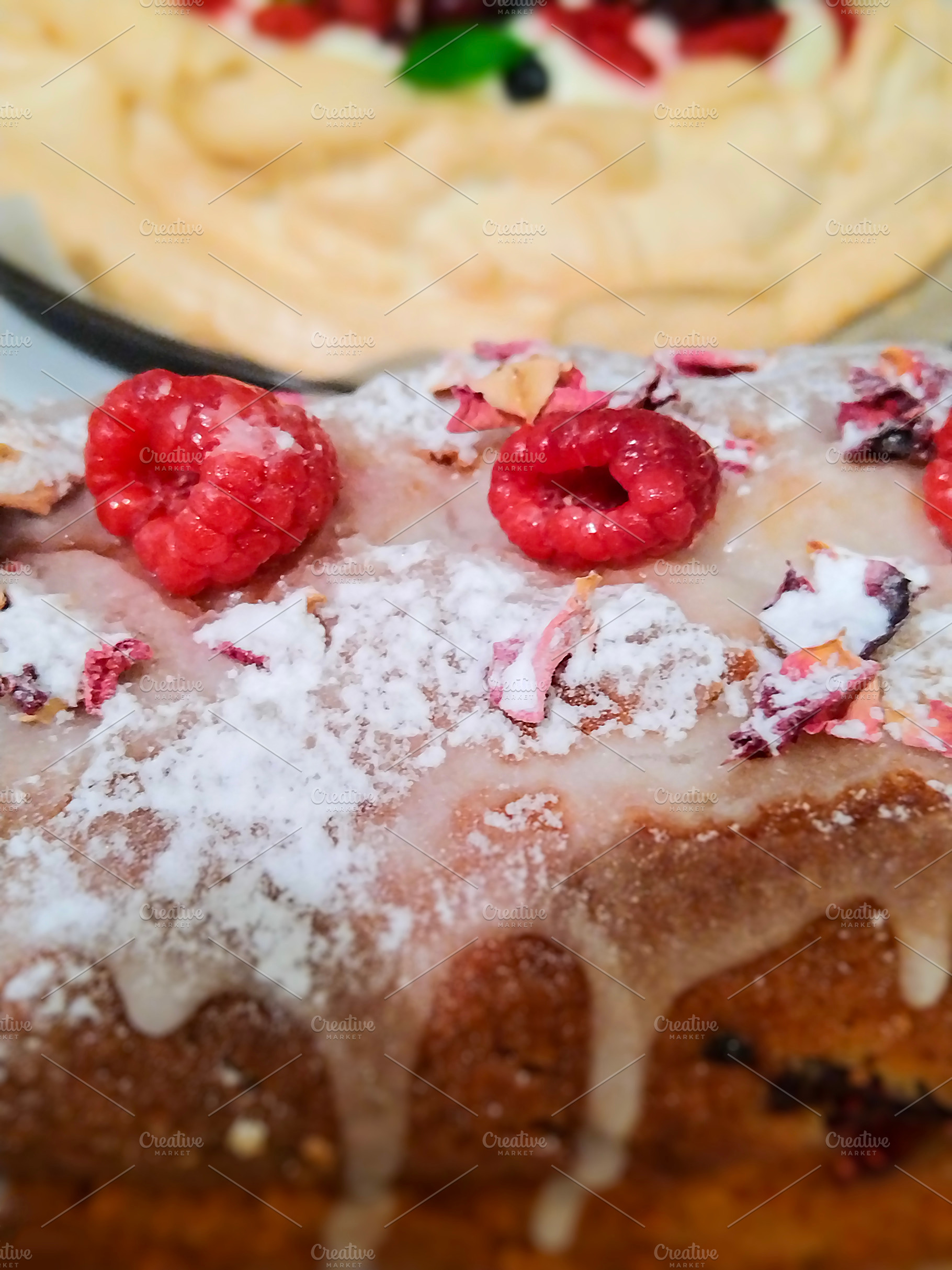Cake with a golden-brown crust, topped sugar and raspberries, a Food & Drink Photo by DanFLCreativo