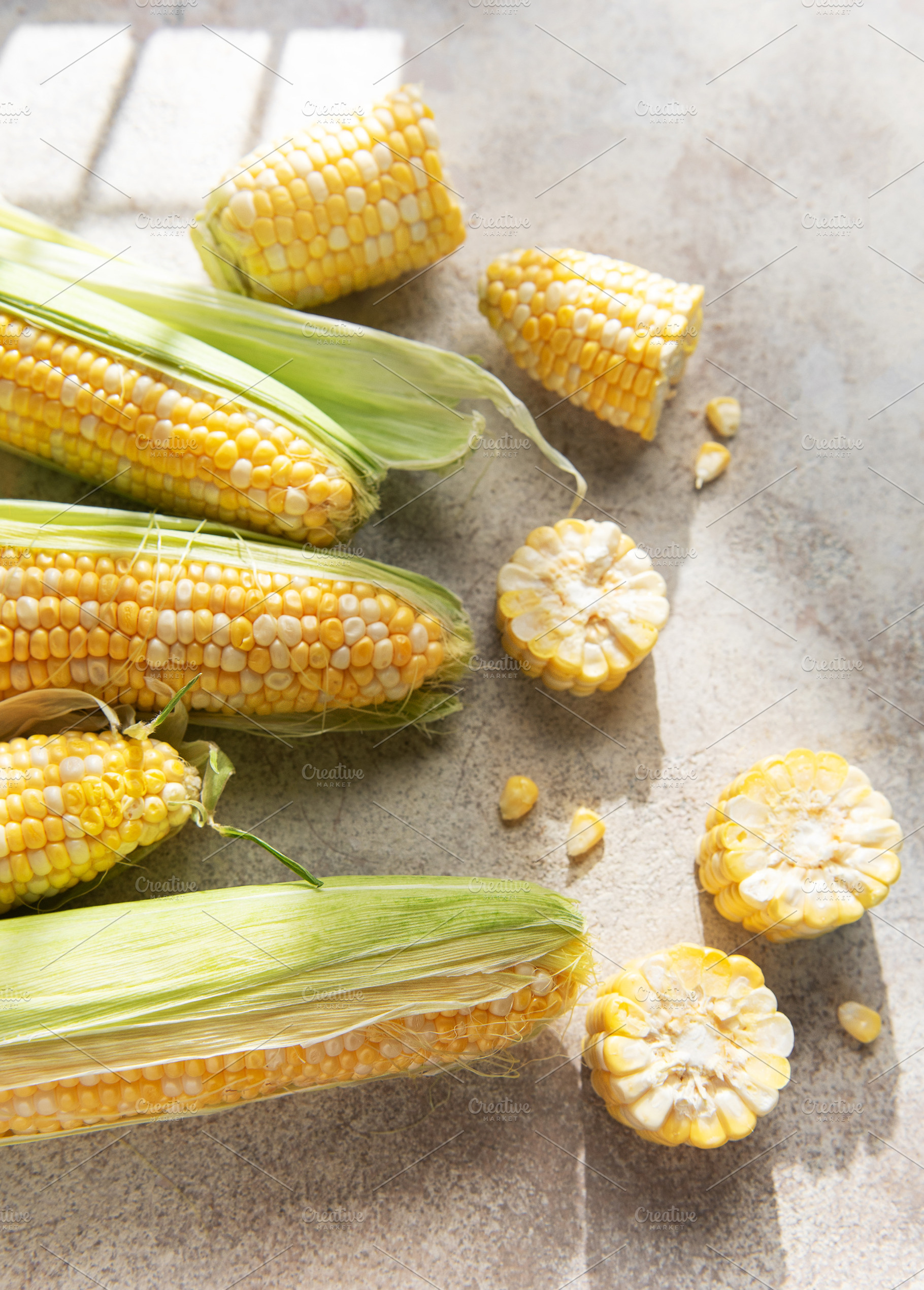 Fresh organic corn cobs and kernels on rustic background, a Food & Drink Photo by Olena Rudo
