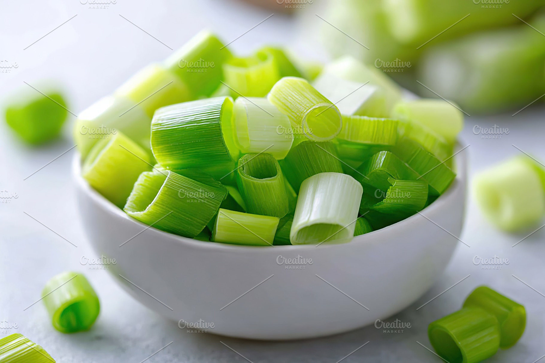 Fresh green chopped scallions in a white bowl ready for cooking and garnishing, a Food & Drink Photo by AlyaAnd