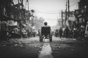 Person in a wheelchair on a crowded street in black and white, a Photo by AS photostudio