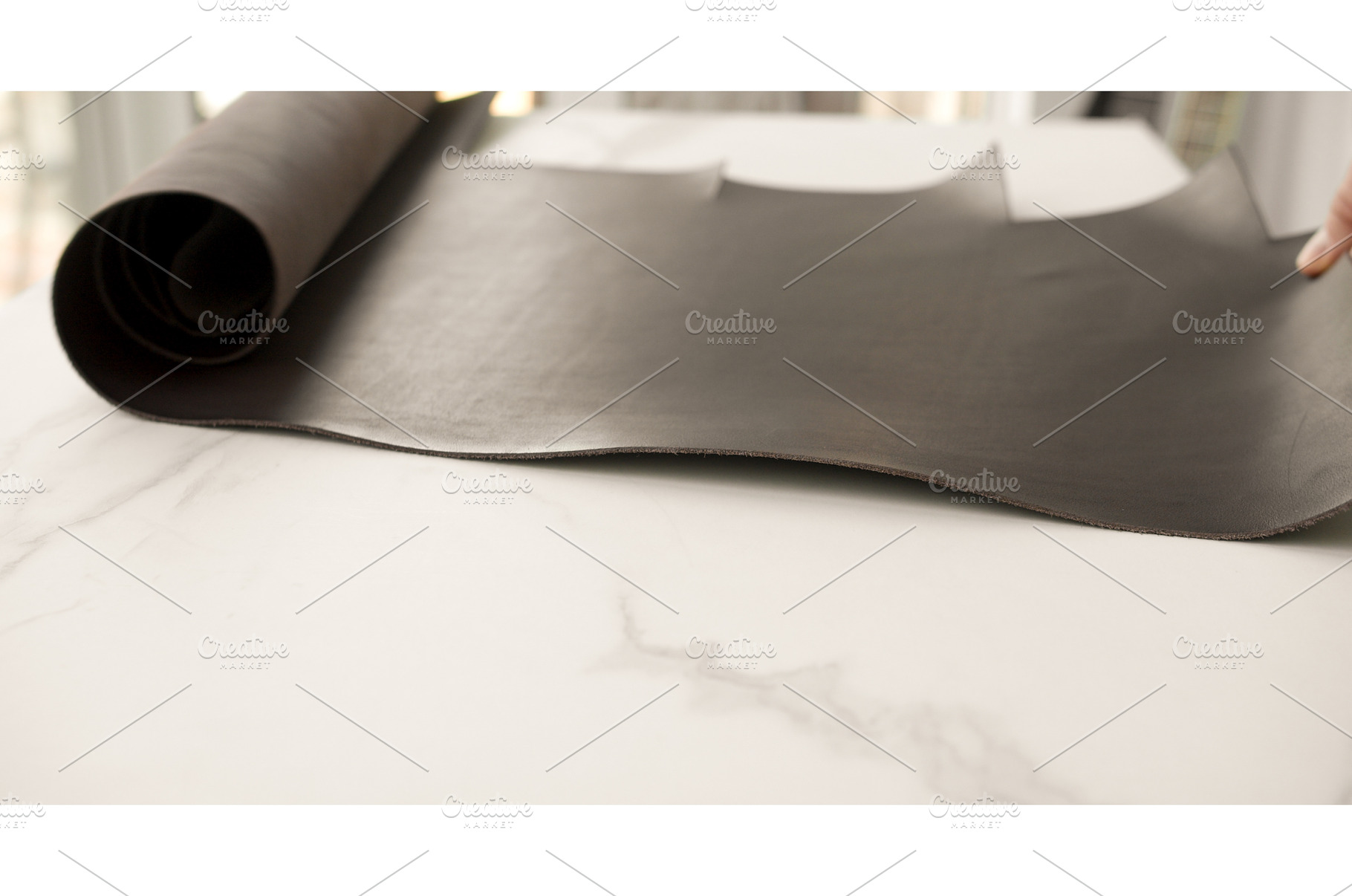 Roll of dark brown leather on white, an Industrial Photo by volodymyrshtun13795