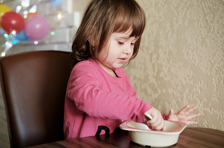 Happy Little Girl Eats With A Spoon While Sitting At Table, a Person Photo by Rohan Photography