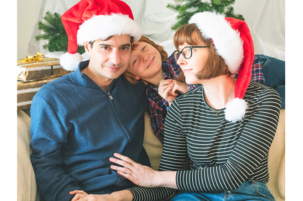 Mother, dad and son in santa caps on, a Holiday Photo by Lifemorning