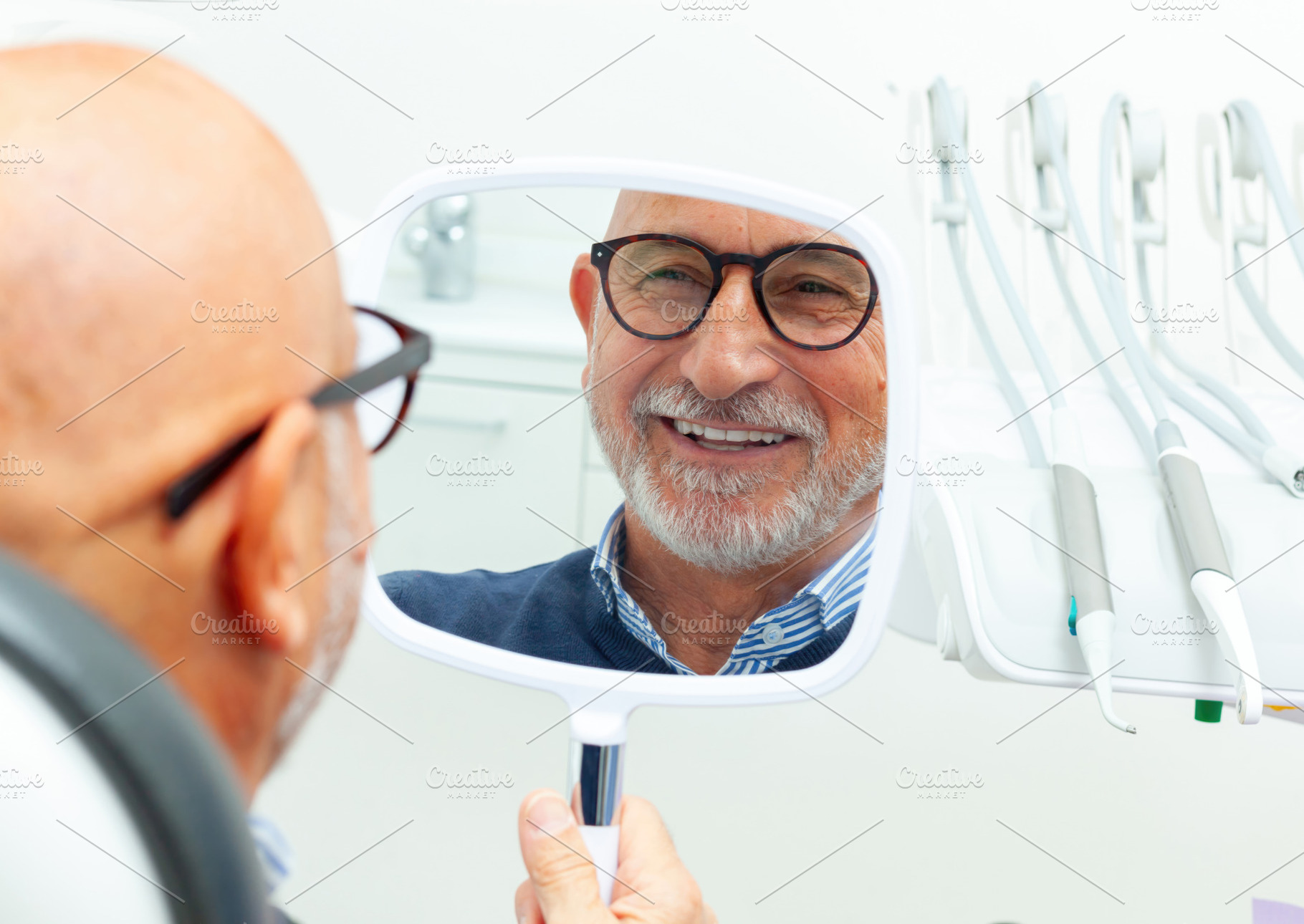 Senior patient admiring his smile after dental procedure, a Health & Medical Photo by Antonio Gravante Market