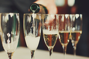 Man pours champagne in wineglasses