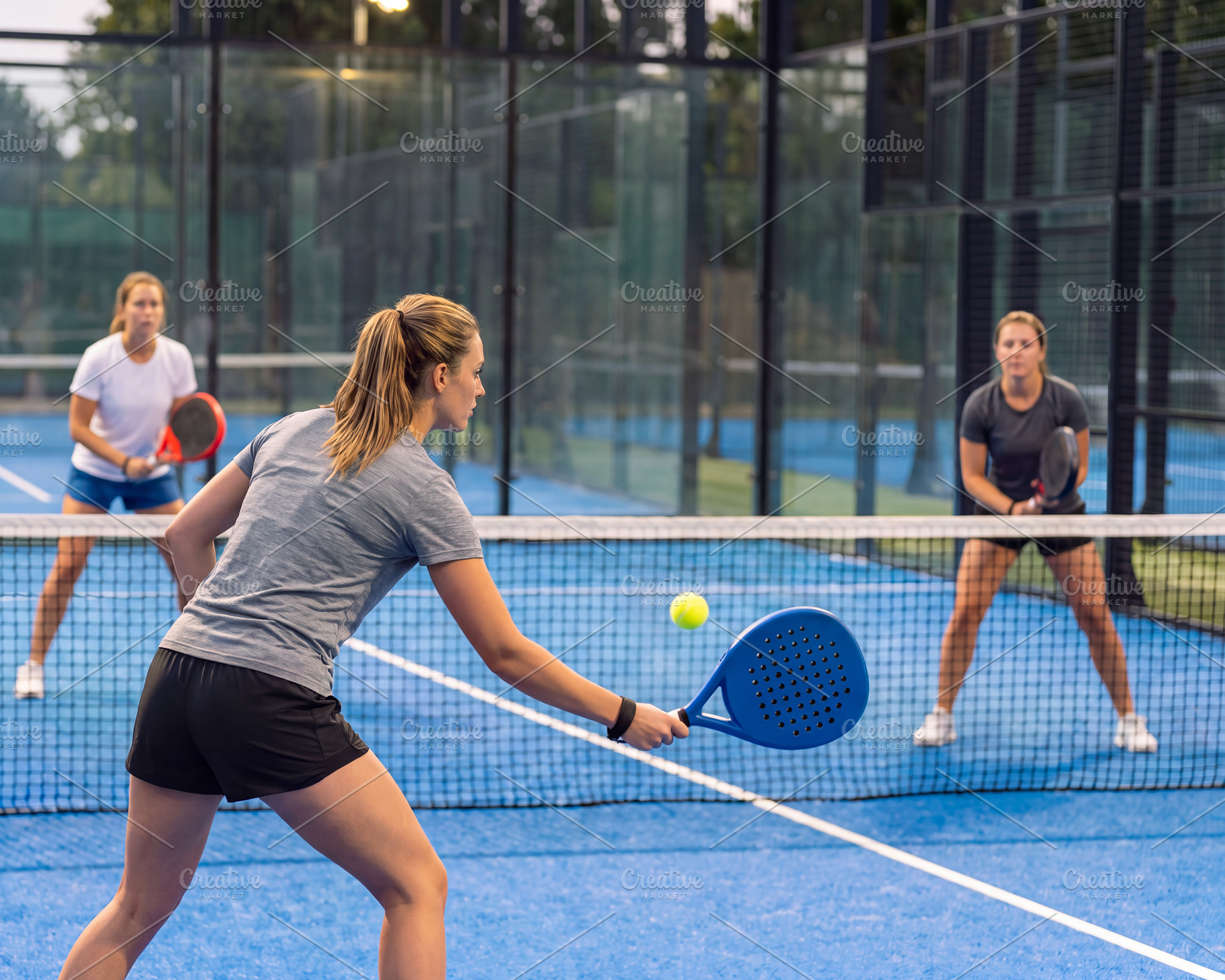 Female padel players in action during match on outdoor court., a Sports & Recreation Photo by Volff