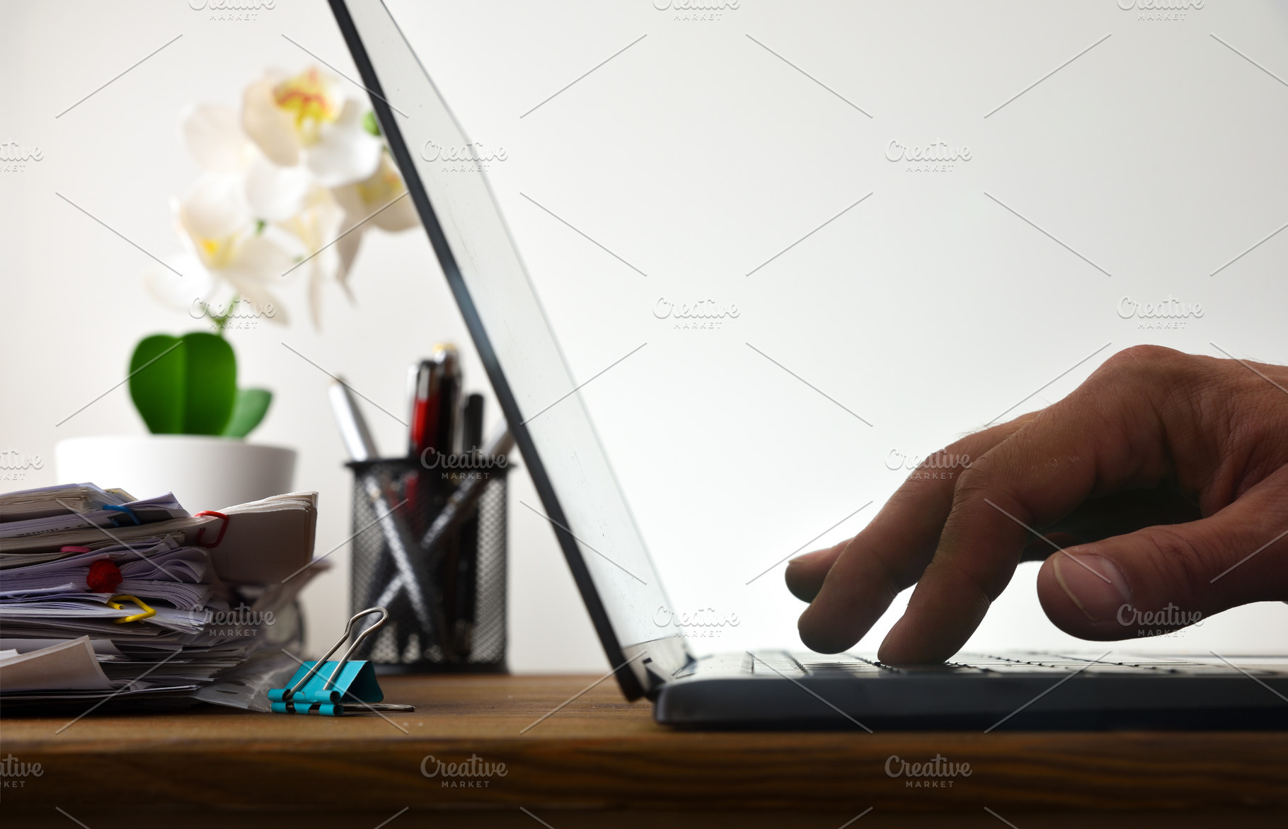 Hand Typing on Laptop Beside Paperwork, a Business Photo by Davizro's Market