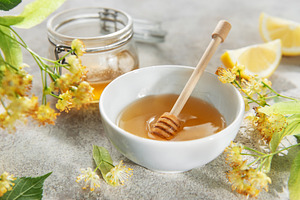 Honey in bowl with dipper and linden flowers, a Food & Drink Photo by Olena Rudo