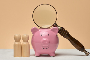 Piggy bank, wooden human figures, above the piggy bank there is, a Business Photo by ndanko